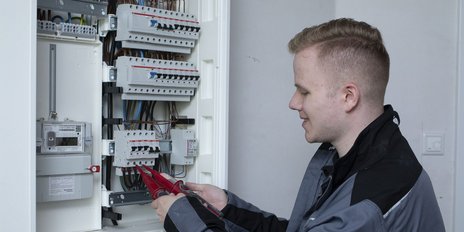 Ein Elektroniker der an einem Verteilerkasten arbeitet