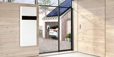 Ein Holzhaus mit einer Photovoltaikanlage und einem E-Auto und einer Wallbox von Vissmann